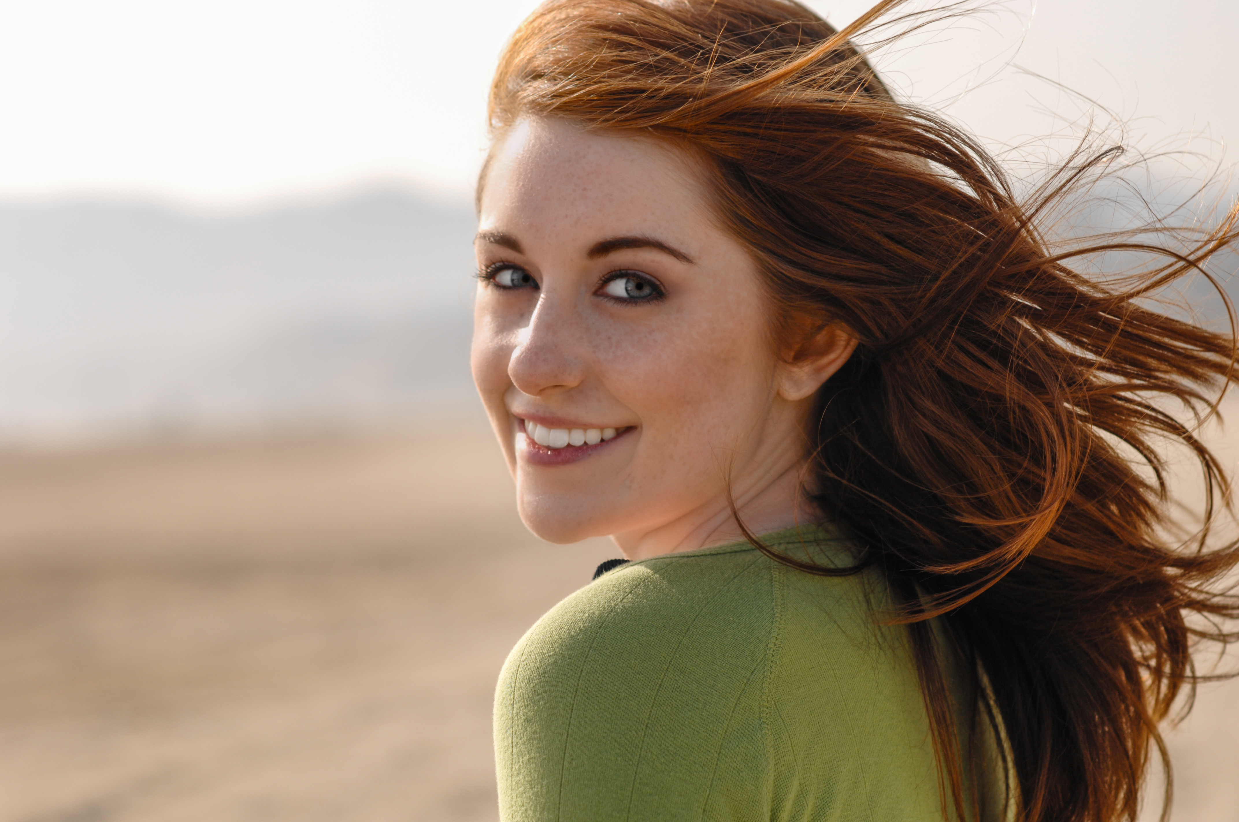 Young redhaired woman at Santa Monica Beach in sweater